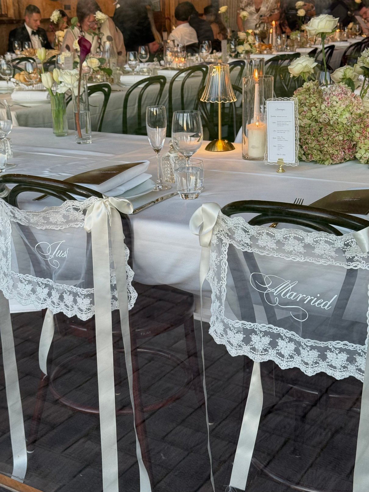 Reception chairs draped in lace reading Just Married